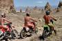 A naked guy riding a motorcycle and his two equally unclad friends.